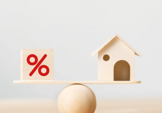 interest rate rise and what it means for homeowners - a balancing act with a block and a house balancing on a plank